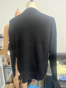 Detailed back view of black ribbed knit sweater with loose fit and textured weave