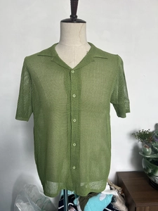 Close-up of green knit polo shirt featuring vertical mesh texture and matching buttons