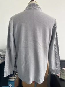 Detail view of grey knit sweater back showing waffle texture and cable knit sleeves