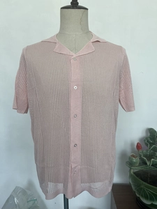 Close-up of pink hollow knit mesh fabric with classic camp collar and buttons