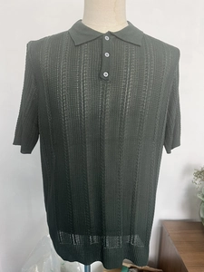 Detail of dark green knit polo shirt with vertical openwork texture and ribbed cuffs