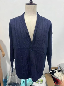 Dettaglio macro della trama a trecce blu navy su questo cardigan invernale da uomo
