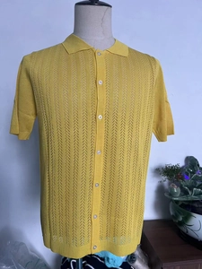 Close-up of yellow knit polo shirt showing openwork geometric texture and button closure