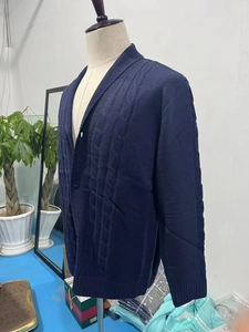 Vista dettagliata del cardigan blu navy con lavorazione a treccia e bottoni sul davanti