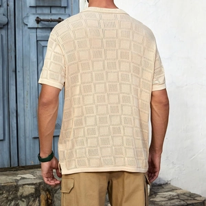 Detail of light beige knitted shirt showing openwork checkerboard texture and side slit