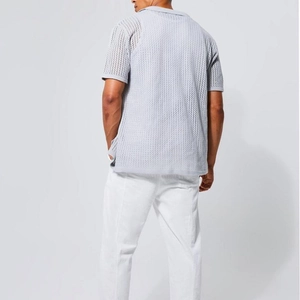 Detail of light grey knit polo with hollow mesh texture for breathable summer wear