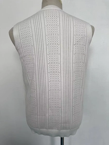 Détail du gilet en maille blanche avec motifs ajourés verticaux et bords-côtes