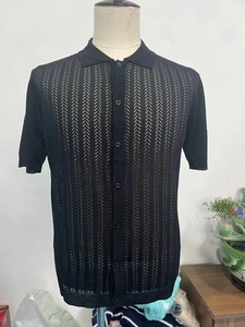 Detail of black short sleeve polo shirt showing vertical hollow knit texture and buttons
