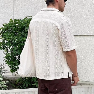 Detail der weißen Häkelstrick-Textur am Herren-Kurzarmhemd für den Sommerurlaub