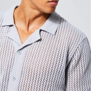 Detail of light blue men's hollow knit polo shirt with breathable texture and buttons
