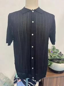 Detail of black knit polo shirt featuring vertical hollow knit texture and white buttons