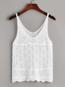 Close-up of white knitted camisole featuring delicate hollow-out crochet pattern and V-neckline