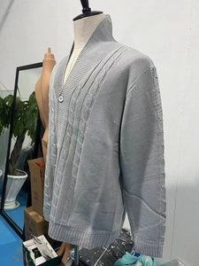 Cardigan da uomo grigio a trecce con collo a scialle e bottoni in primo piano