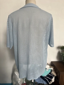 Rear view of light blue mesh knit short sleeve shirt with breathable textured fabric