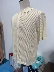 Detailed macro view of the breathable hollow knit texture and buttons on the beige polo shirt