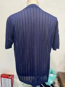 Detailed view of blue short sleeve knit shirt with vertical hollow stripes and black trim