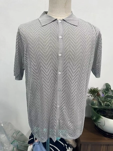 Detail of grey knitted polo shirt showing the wave hollow stitch pattern and buttons