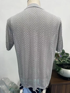 Detailed view of men's grey knit polo shirt featuring an intricate chevron texture