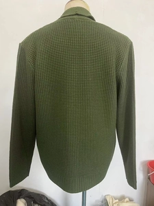 Rear view of dark olive green knit cardigan with waffle texture and ribbed cuffs