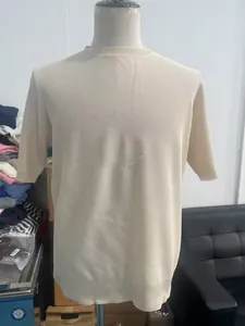 Detail of beige knit short sleeve t-shirt featuring textured waffle fabric on mannequin
