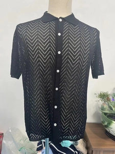 Close-up of black knit polo shirt featuring wave hollow texture and white buttons