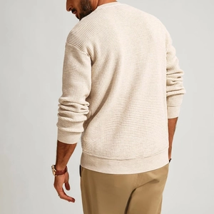 Detailed back view of a men's waffle knit sweater in cream color with ribbed cuffs