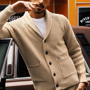 Detail of light tan men's knit cardigan with shawl collar and waffle texture in outdoor setting