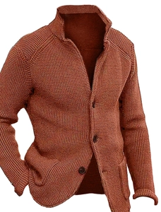 Detail of brick red knit cardigan featuring thick checkered texture and button closure
