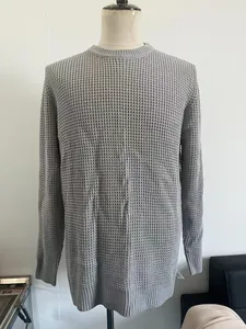 Detail showing grey waffle knit texture and ribbed cuffs of men's crewneck sweater