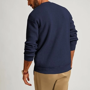 Rear view of men's dark blue waffle knit sweater with ribbed cuffs and crew neck detail