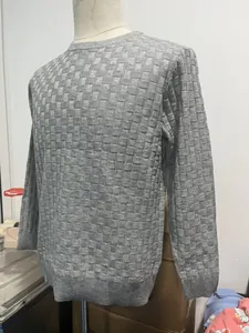 Detail showing the intricate basketweave texture and ribbed cuffs of this grey knit sweater