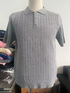 Detaillierte Makroansicht des grauen Strickmusters und Rippbündchens an einem Herren-Polo