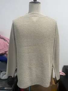 Close-up of beige waffle knit sweater featuring heavy texture and ribbed cuff details