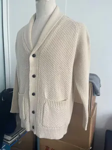Close-up of beige waffle knit cardigan showing shawl collar and contrast buttons