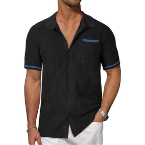 Detail of black knit polo shirt featuring blue stripes on the pocket and sleeve cuffs