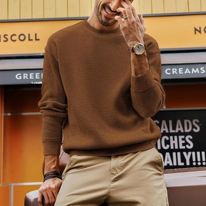 Close-up of brown waffle knit texture on a men's long-sleeve crewneck sweater