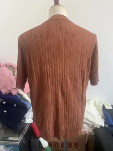 Close-up of brown knit polo shirt with vertical hollow-out texture and ribbed cuffs