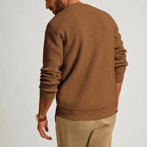 Macro shot showing solid color waffle knit texture and ribbed cuffs of the men sweater