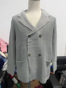 Detail of light gray double-breasted knit cardigan with lapel and pockets