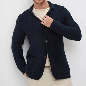 Détail du blazer en maille bleu marine avec texture gaufrée, col à revers et boutons