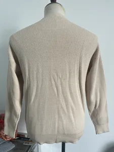 Rear view of a beige waffle knit sweater for men with ribbed cuffs and hem on a mannequin