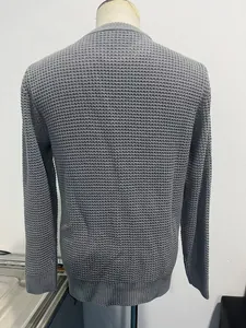 Detailed back view of grey waffle knit sweater featuring ribbed cuffs and hem on a mannequin