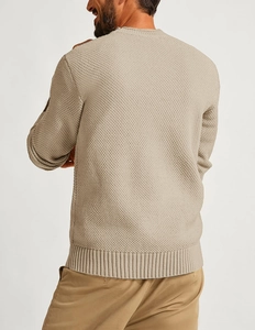 Detail view of beige waffle knit sweater showing textured fabric and ribbed cuff finish