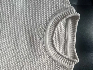 Close-up of the ribbed crew neck and waffle knit texture on a beige men sweater
