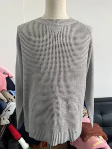 Detail of grey crewneck knit sweater showing textured waffle pattern on back view