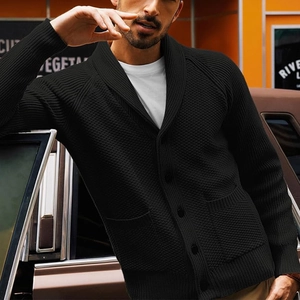 Close-up of men's black knit cardigan featuring shawl collar and textured button details