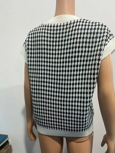 Détail du dos d'un gilet en tricot pied-de-poule avec bordure côtelée au col et à l'ourlet