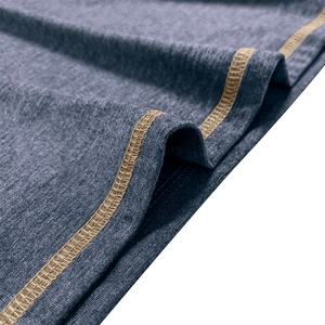 Detailed close-up of dark blue knit fabric with contrast khaki stitching on a polo shirt