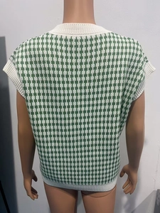 Détail du gilet en maille pied-de-poule vert et blanc avec finitions en côtes