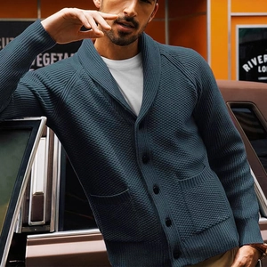 Detail of blue-grey knit cardigan featuring shawl collar and waffle weave texture